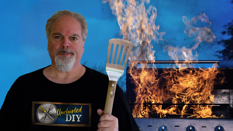 perturbed man holding bbq spatula while gas grill is on fire in background