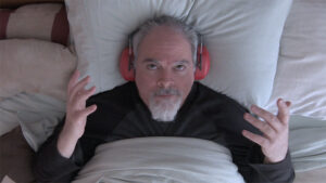 wearing hearing protection in bed with exasperated expression